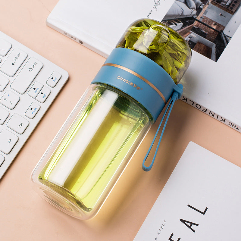 Clear water bottle with blue band and green liquid on a desk with keyboard and papers