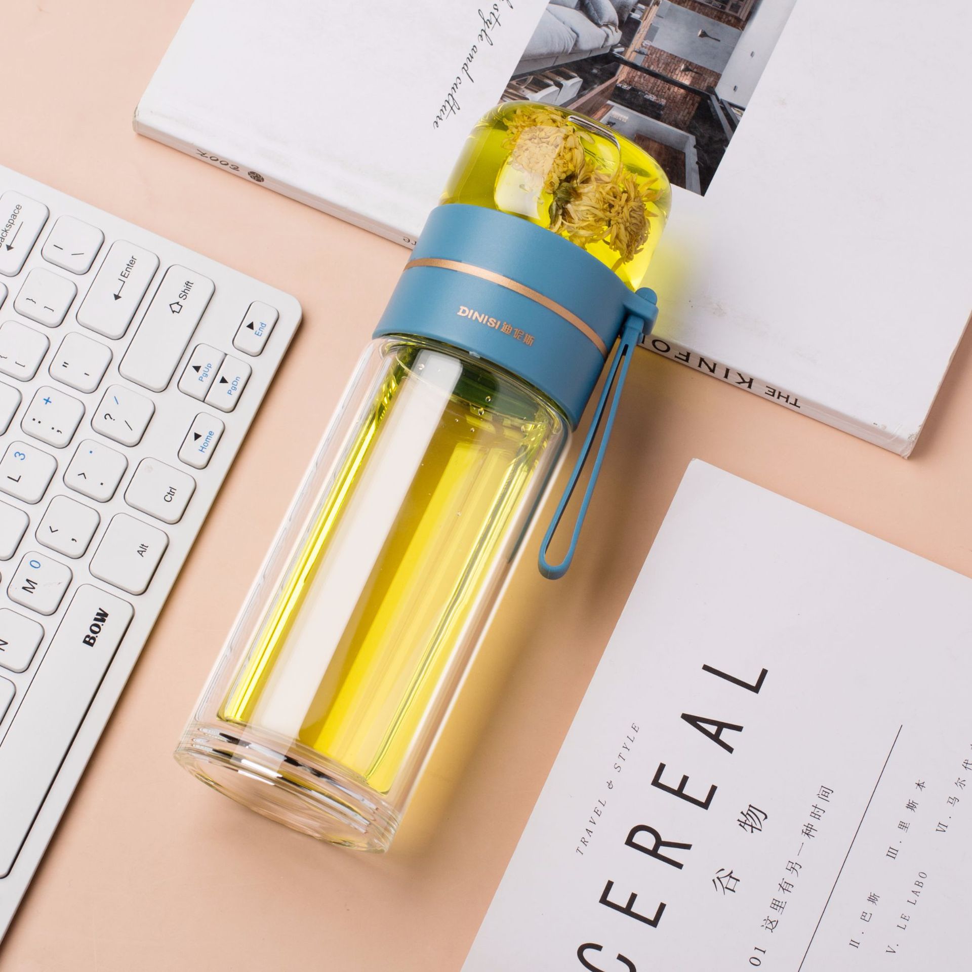 Clear water bottle with blue lid on a desk with a keyboard and papers
