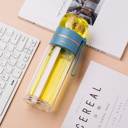 Clear water bottle with blue lid on a desk with a keyboard and papers