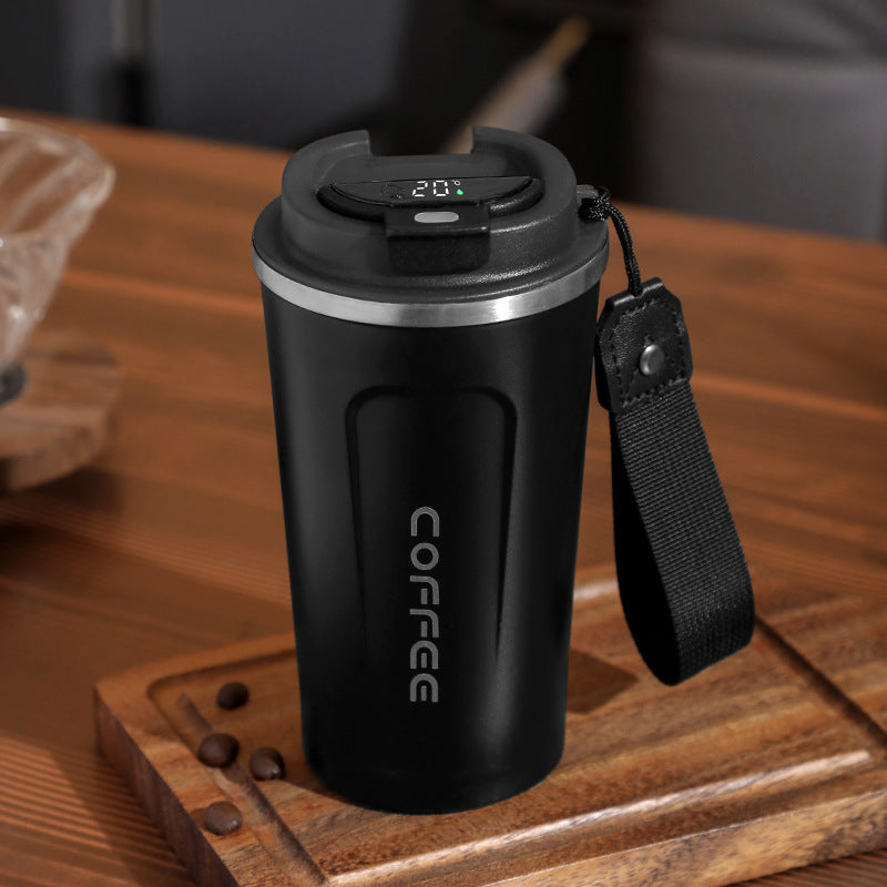 Black coffee mug with digital display on a wooden surface