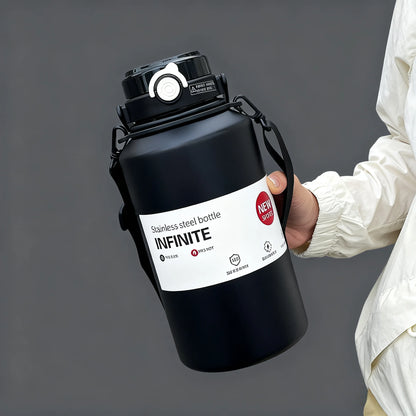 Person holding a black stainless steel bottle labeled 'INFINITE' against a gray background