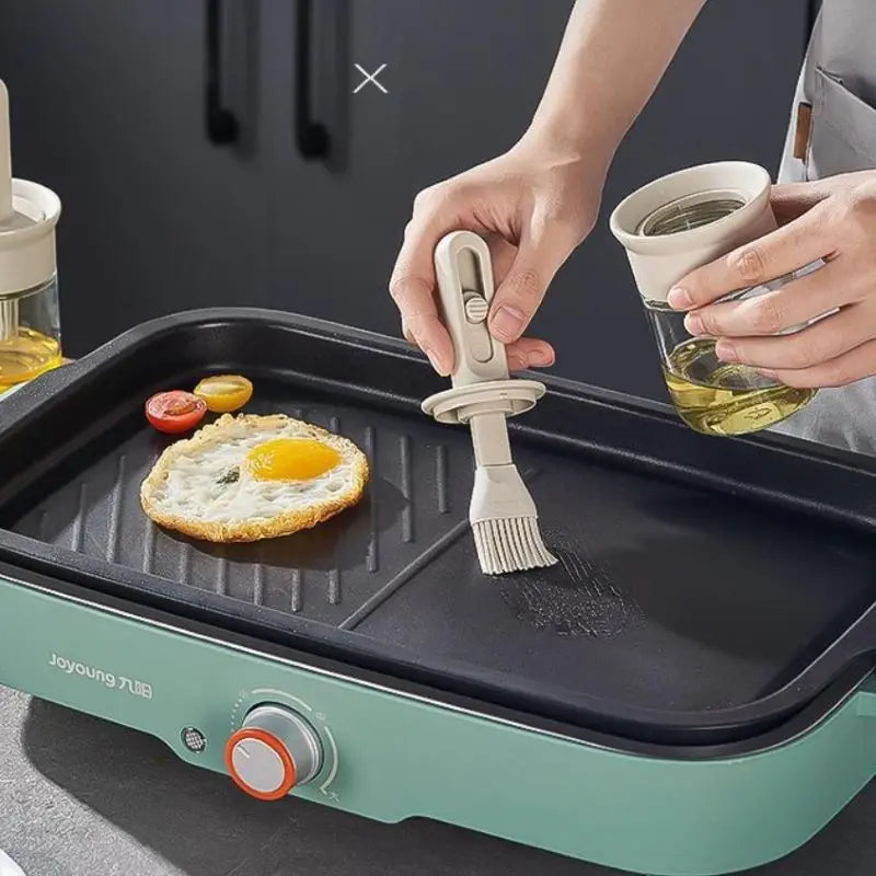 Person cooking eggs on a portable grill with a brush and oil container.