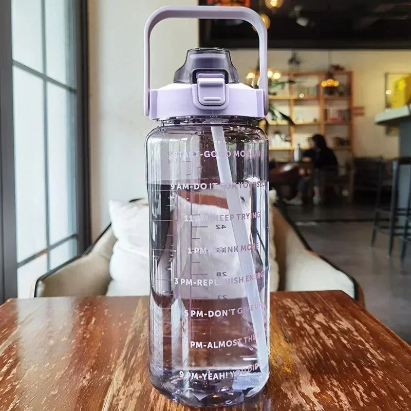 Clear water bottle with measurements and text on a wooden table in a cafe setting