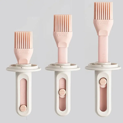 Three silicone basting brushes with pink bristles and beige handles on a light gray background.