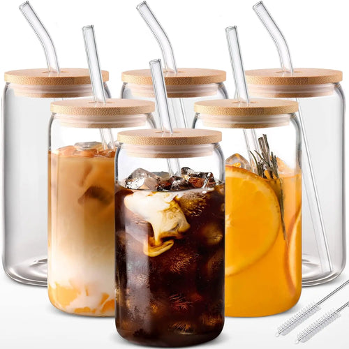 Set of glass jars with wooden lids and straws, containing iced beverages.
