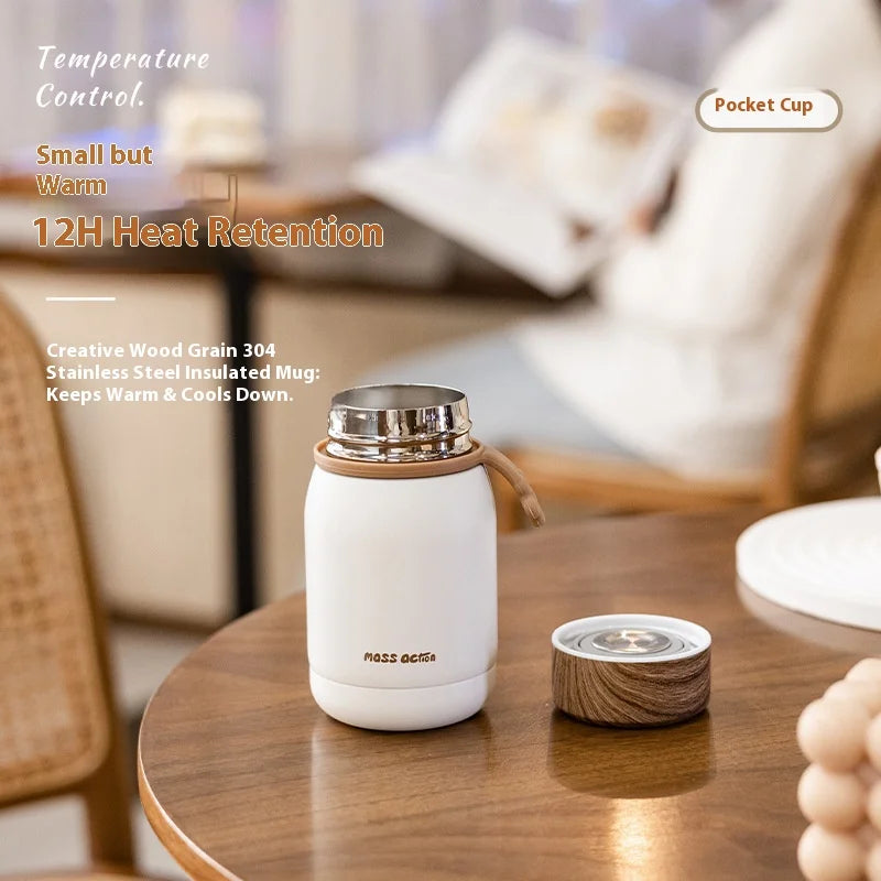 White insulated mug with wooden accents on a wooden table, with text highlighting features.