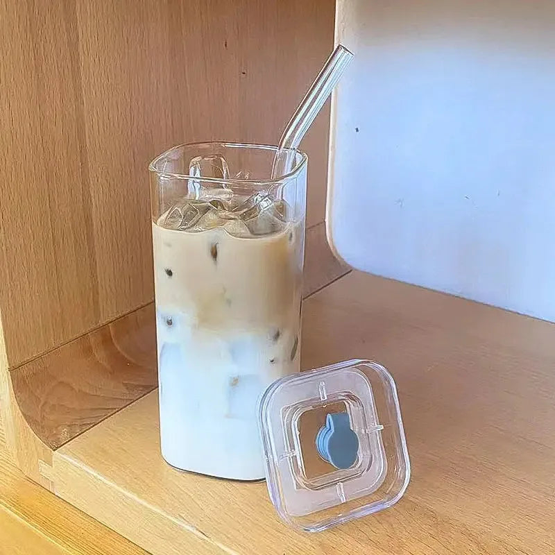 Glass of iced coffee with a straw on a wooden surface