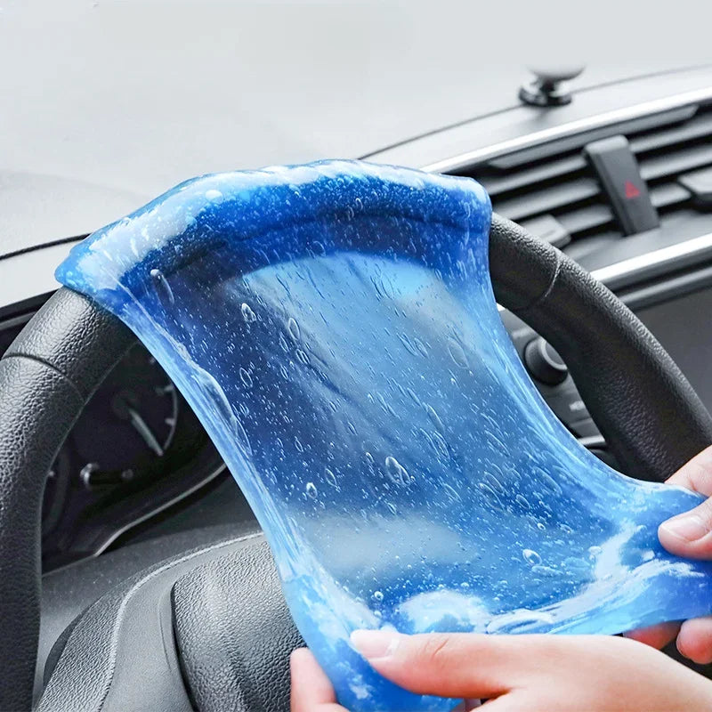 Blue slime being held over a car's interior