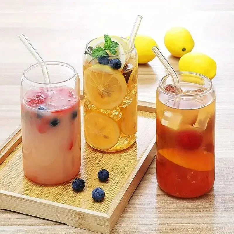 Three glasses of iced drinks with fruits and straws on a wooden tray.