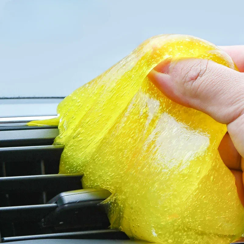 Hand using a yellow sponge to clean an air conditioner.
