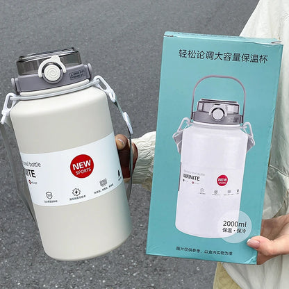 White sports bottle with gray lid held by a person, next to its packaging box on a gray surface.