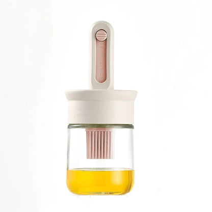 Glass container with a pink lid and handle, filled with a yellow liquid on a white background