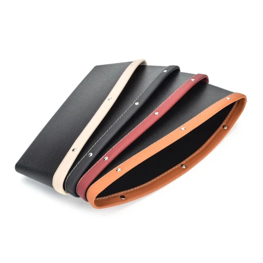Set of black leather belts with beige, red, and brown straps on a white background