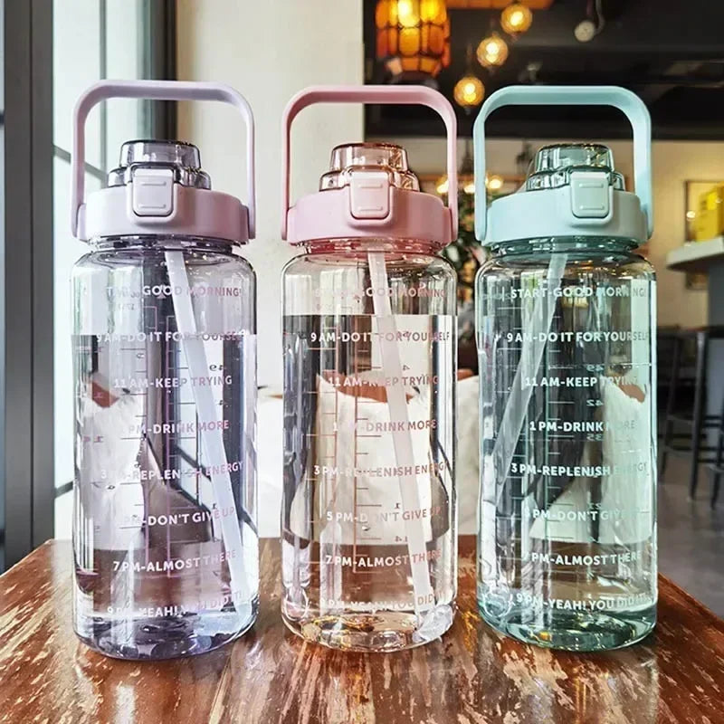 Three transparent water bottles with colorful lids on a wooden surface.