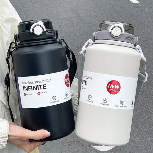 Two stainless steel bottles, one black and one white, held by a person against a gray background.